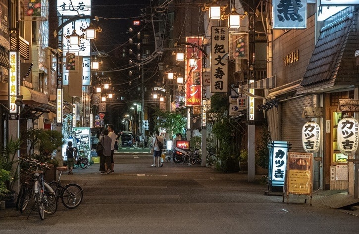 a nearly empty street with lights from restaurants at night in Asakusa in Tokyo