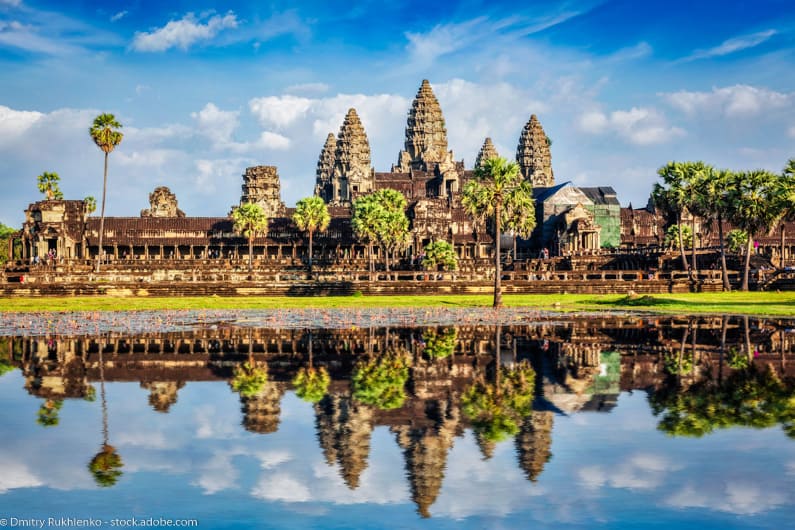 Angkor Wat with reflection of temple in water under a blue sky