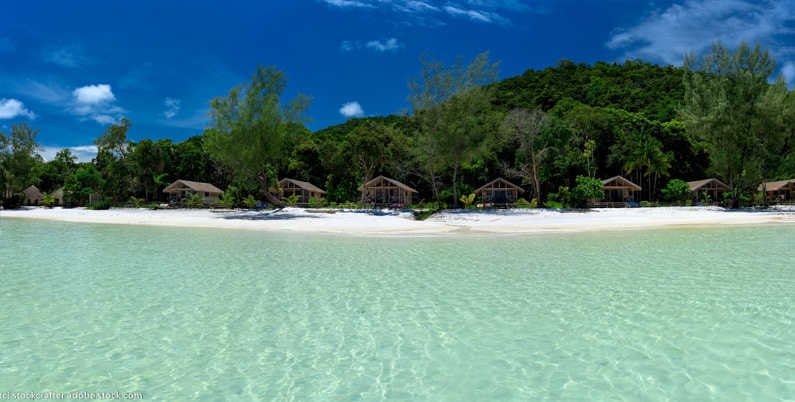 crystal clear water and beach lined with bungalows on Koh Rong Samloem, Cambodia