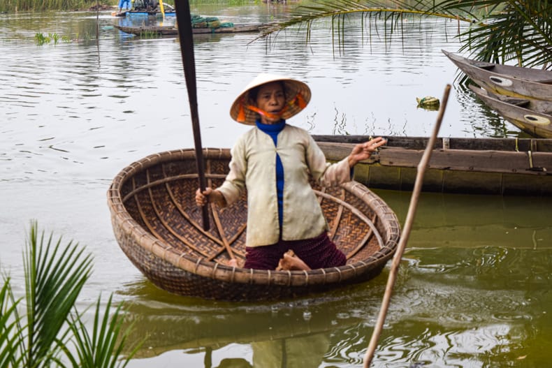 a woman in a basket boat in Hoi An