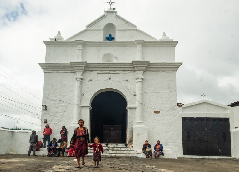 a mother and daughter walking out of Capilla del Calvario in Chichicastenango