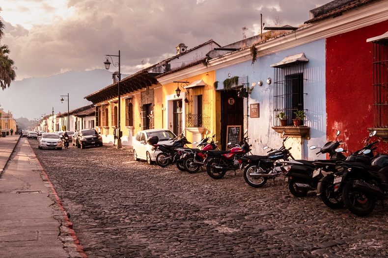 a cobblestoned street lined with colorful colonial buildings