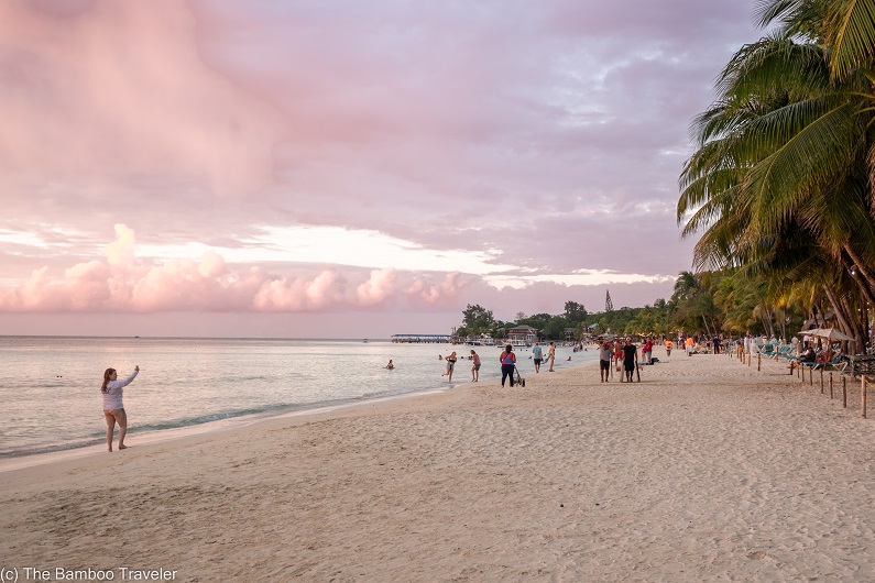 people walking down West Bay end at sunset, one of the best places to visit in Central America