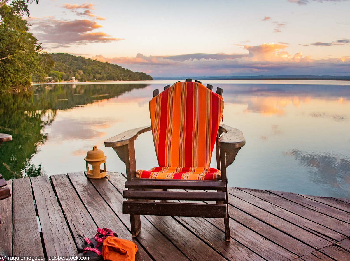a chair on a dock next to Lake Peten