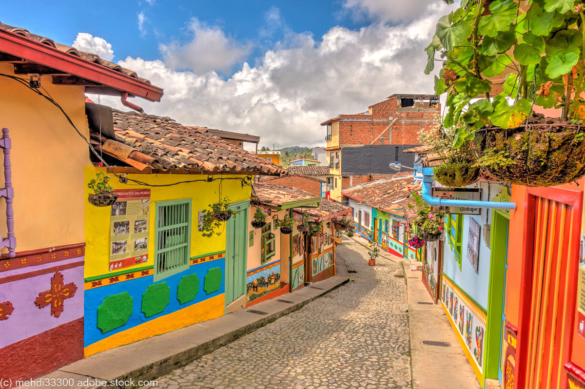 a narrow street lined with colorful spanish colonial buildings