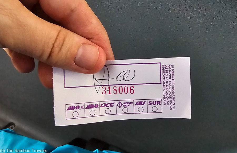 two fingers holding a small piece of paper, which is a luggage ticket