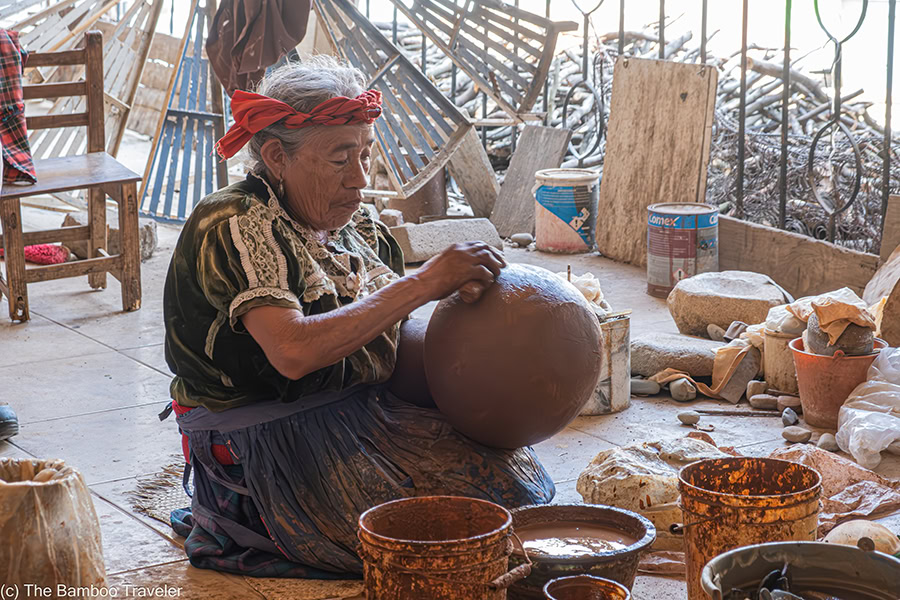 a woman sanding a piece of pottery