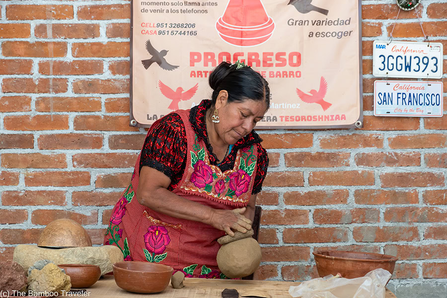 a woman making red clay pottery on the En Via Tour in Oaxaca