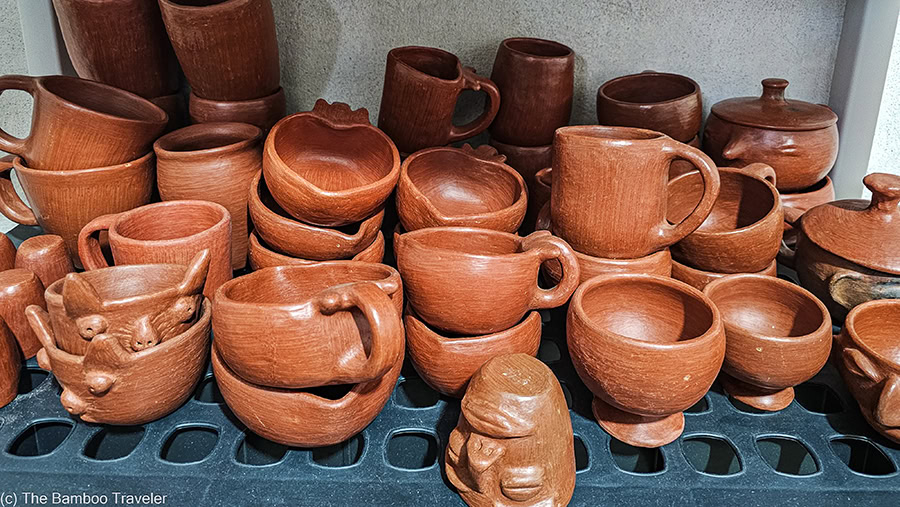 a shelf of cups of red clay pottery