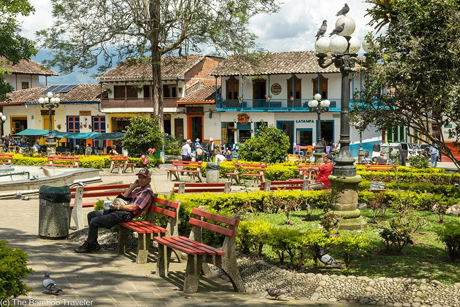 a man sitting on a bench in a park in Jardin