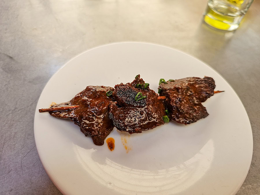 A skewer of chunks of beef heart on a plate