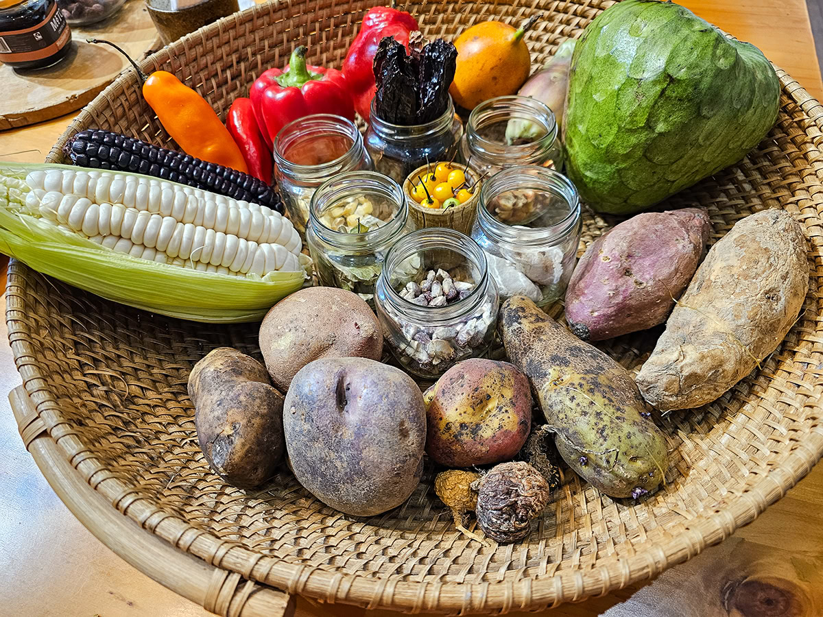 Peru – Lima – Exquisito Food Tour – 113953 A bowl of Peruvian food including potatoes, chirimoya, corn, and chili peppers