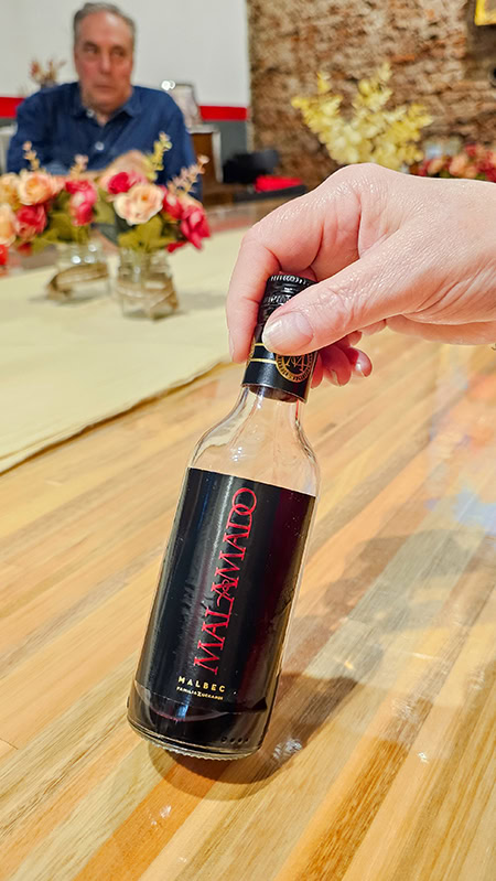 a hand holding a bottle of malamado malbec wine